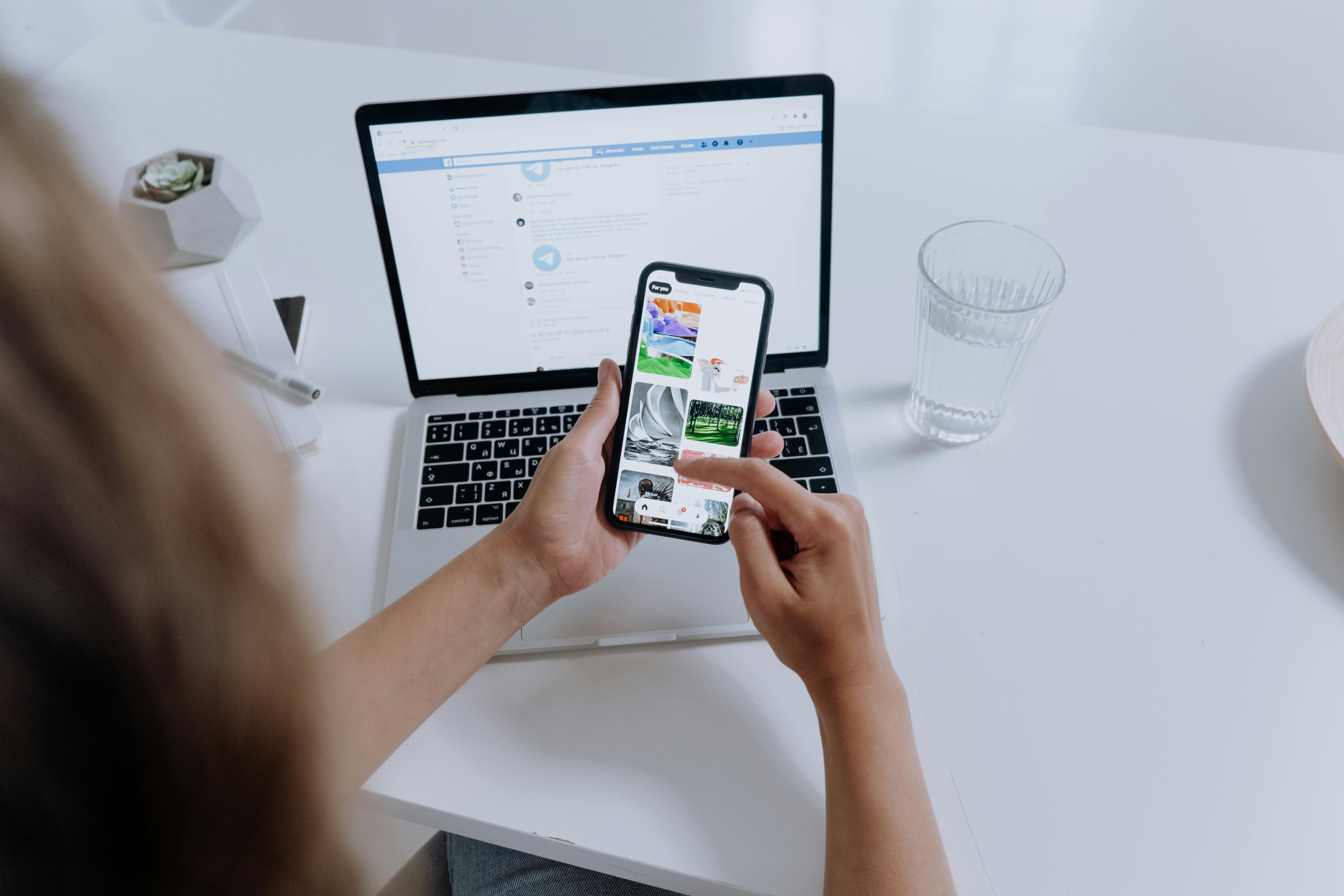 person using phone and laptop