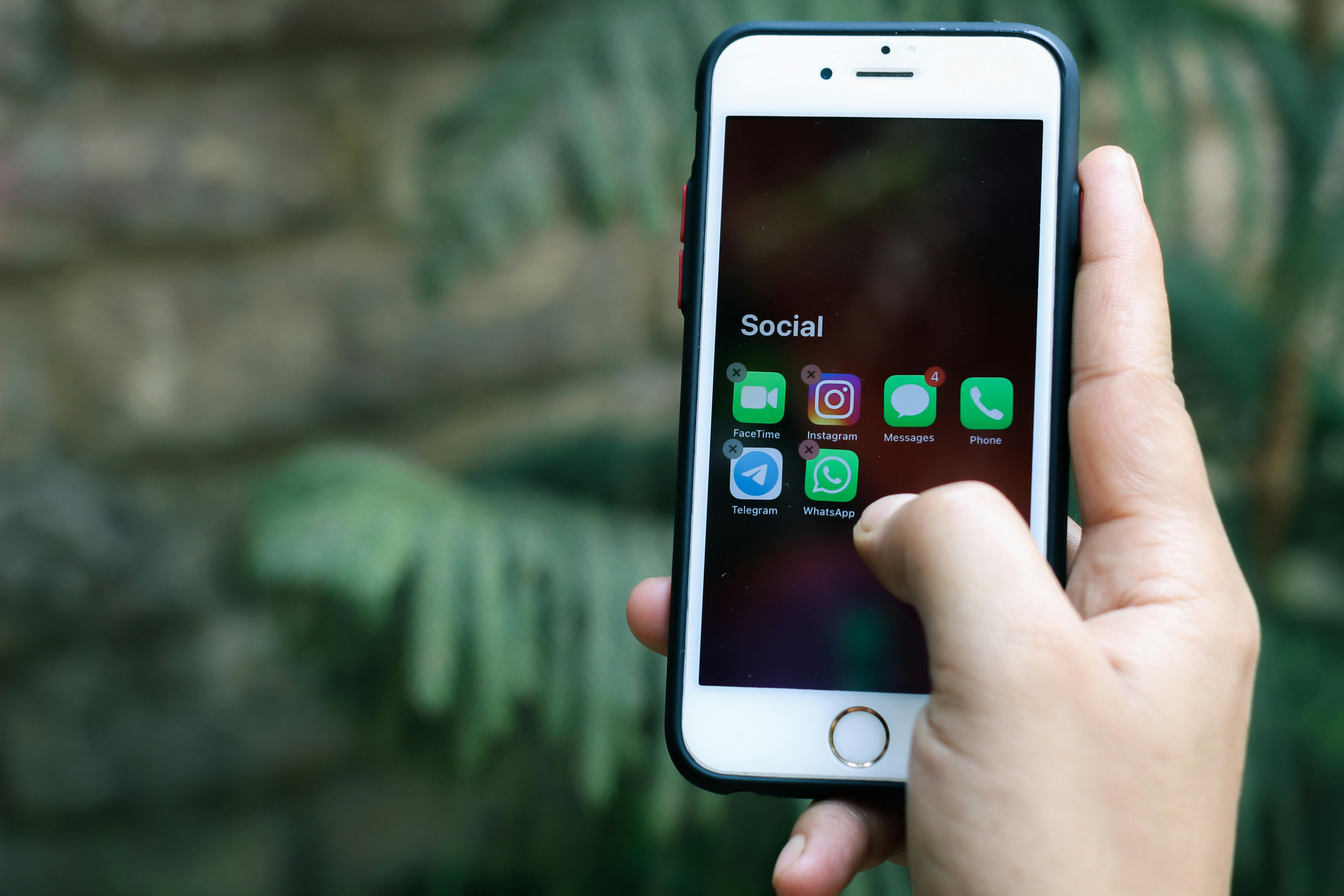 hand holding phone with social apps