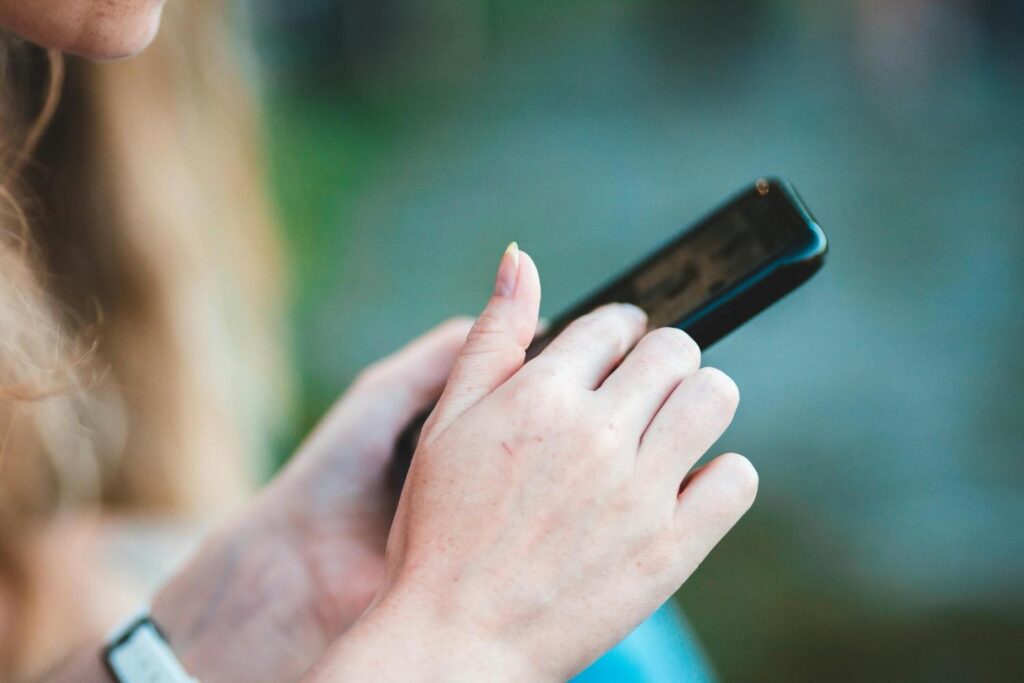 Seorang wanita menggunakan telefonnya di luar